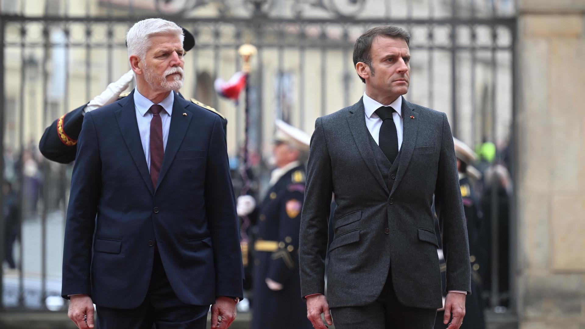 Petr Pavel und Emmanuel Macron vor einem schmiedeeisernen Tor.