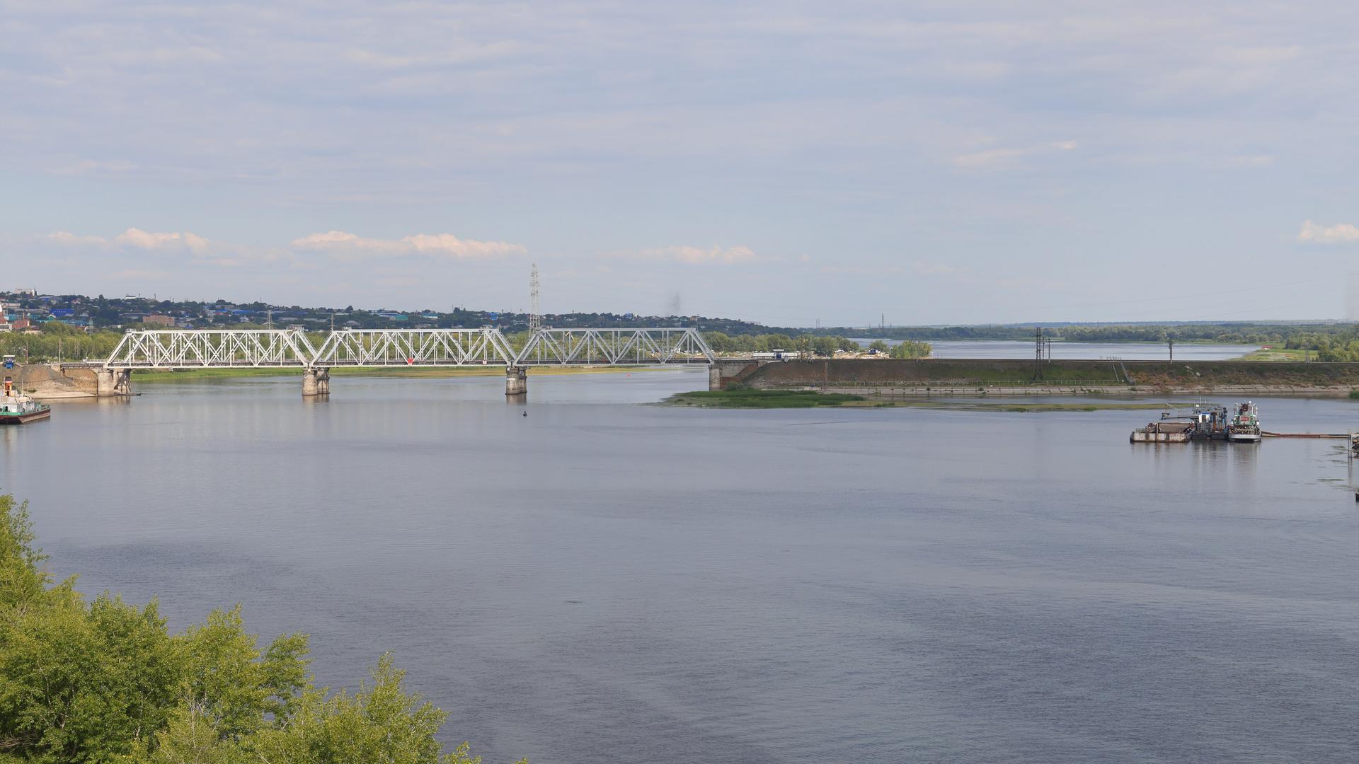 Blick auf eine Eisenbahnbrücke über einem Fluss