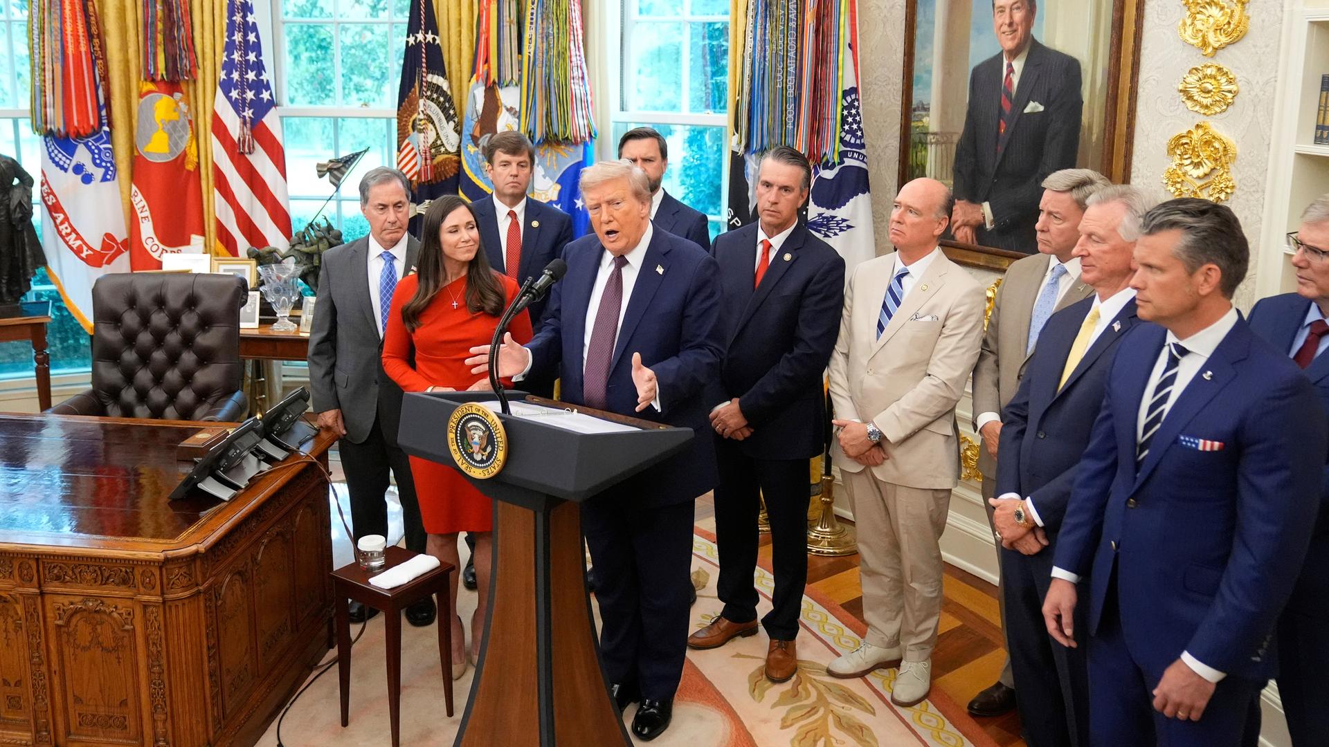 Präsident Trump spricht im Oval Office des Weißen Hauses. Um ihn herum stehen zahlreiche Menschen. Präsident Trump spricht im Oval Office des Weißen Hauses. Um ihn herum stehen zahlreiche Menschen.