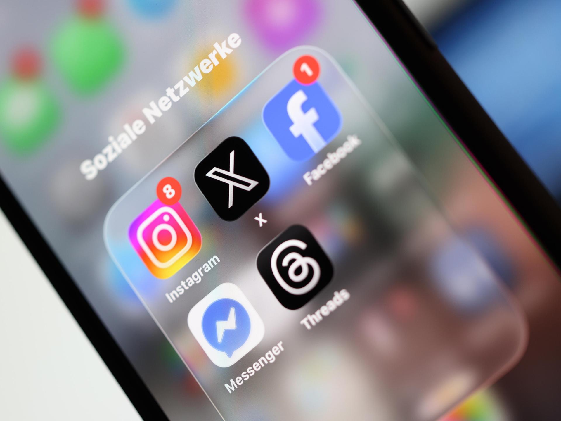 Ein Smartphone-Display zeigt Symbole verschiedener Apps sozialer Netzwerke, darunter X, Facebook, Instagram, Threads und Messenger.