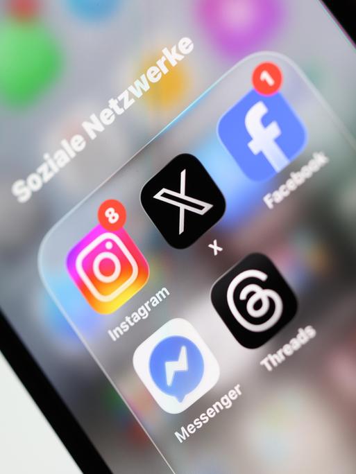 Ein Smartphone-Display zeigt Symbole verschiedener Apps sozialer Netzwerke, darunter X, Facebook, Instagram, Threads und Messenger.