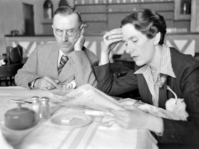 Erika Mann und ihr Vater Thomas Mann sitzen gemeinsam an einem Tisch in Tulsa, Oklahoma. Erika Mann liest Zeitung. USA 1939.