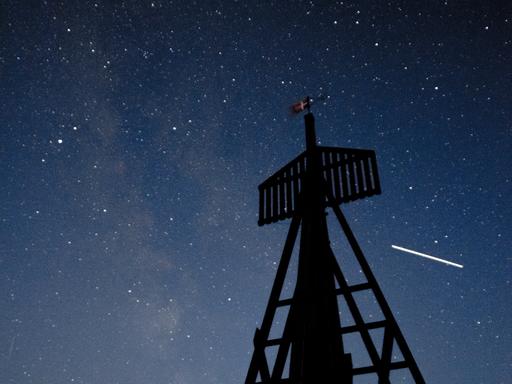 Auf dieser 15 Sekunden langen Belichtung ist die über den Himmel ziehende ISS zu einem Strich geworden. Im Vordergrund ist Æ Kåver zu sehen, das älteste Seezeichens Dänemarks.