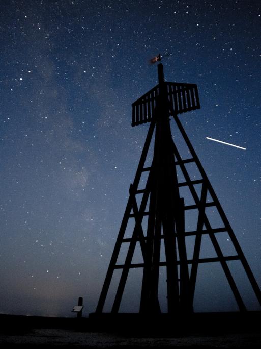 Auf dieser 15 Sekunden langen Belichtung ist die über den Himmel ziehende ISS zu einem Strich geworden. Im Vordergrund ist Æ Kåver zu sehen, das älteste Seezeichens Dänemarks.