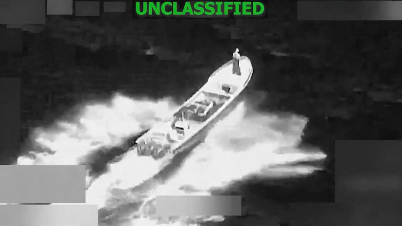 Die schwarz-weiße Kameraaufnahme zeigt ein Schiff im Meer, über dem "Unclassified" in grünen Großbuchstaben geschrieben ist.