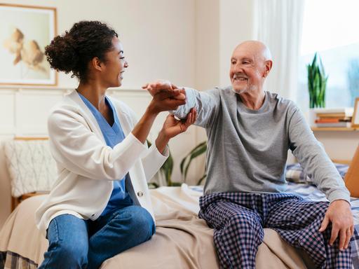 Eine Pflegekraft hat Spaß bei der Arbeit mit ihrem Patienten.