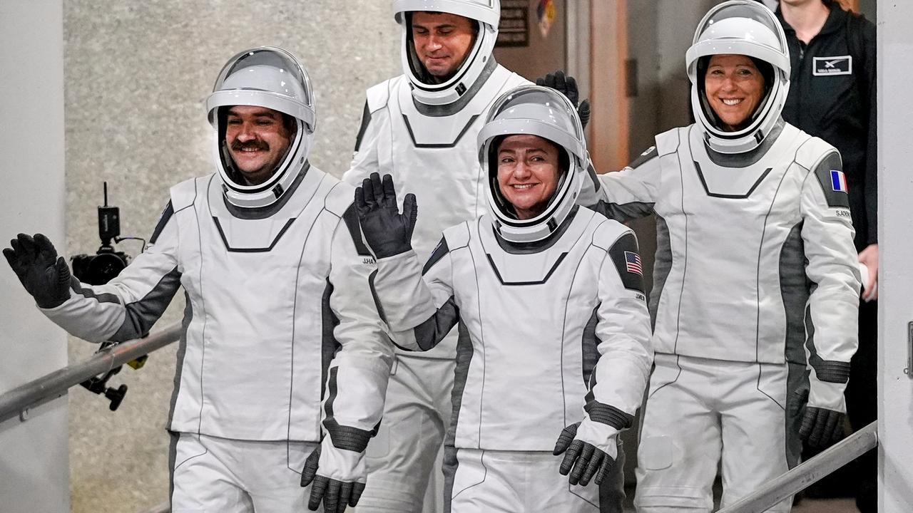 Das Bild zeigt vier Raumfahrerinen und Raumfahrer in ihren Schutzanzügen und mit Helm vor dem Abheben ihrer Rakete.