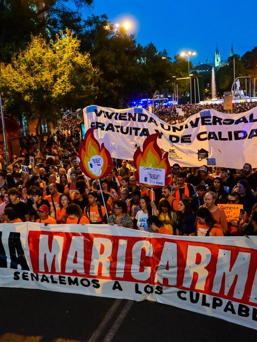 Demonstrierende ziehen in Madrid mit Bannern durch die Straßen, vorweg tragen sie ein großes Banner mit der Aufschrift "Ni una Maricarmen más" ("Keine weitere Maricarmen").

