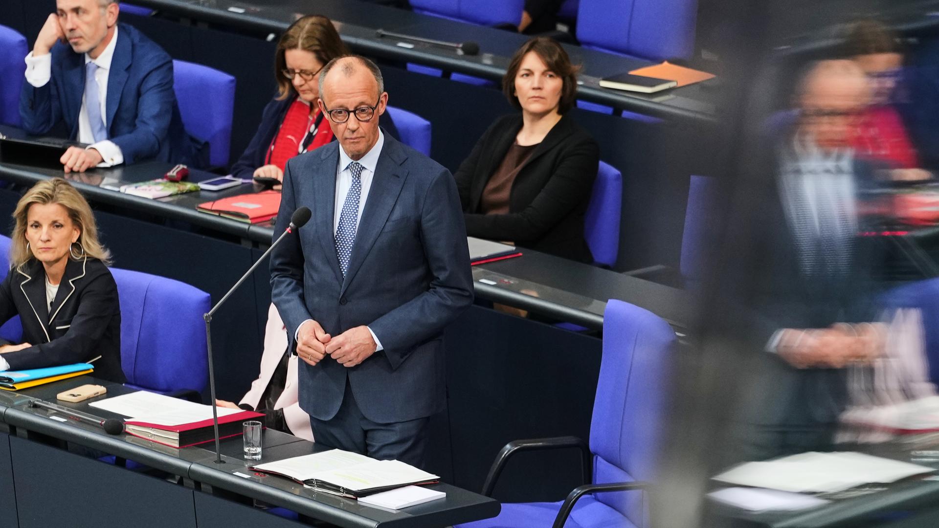 Kanzler Friedrich Merz bei der Regierungsbefragung im Bundestag. Er steht an seinem Platz hinter einem Mikrofon. Kanzler Friedrich Merz bei der Regierungsbefragung im Bundestag. Er steht an seinem Platz hinter einem Mikrofon.