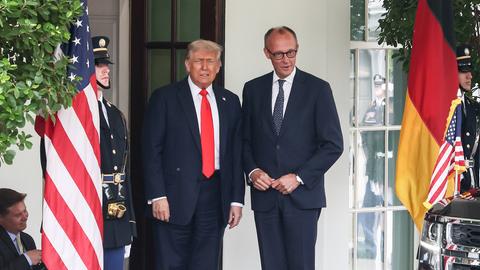 US-Präsident Donald Trump und Bundeskanzler Friedrich Merz nebeneinander vor dem Weißen Haus, neben ihnen sind die amerikanische und die deutsche Flagge gehisst.