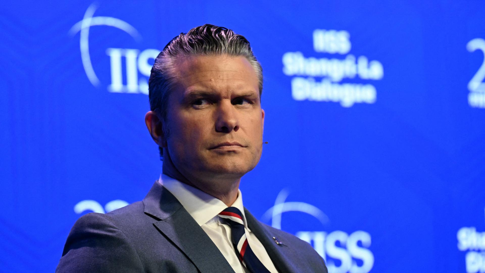 US-Verteidigungsminister Hegseth blickt beim Sicherheitsforum in Singapur mit ernster Miene einen Gesprächspartner an.