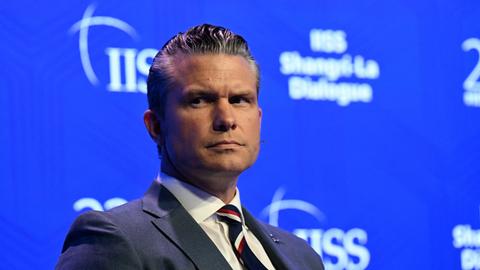 US-Verteidigungsminister Hegseth blickt beim Sicherheitsforum in Singapur mit ernster Miene einen Gesprächspartner an.