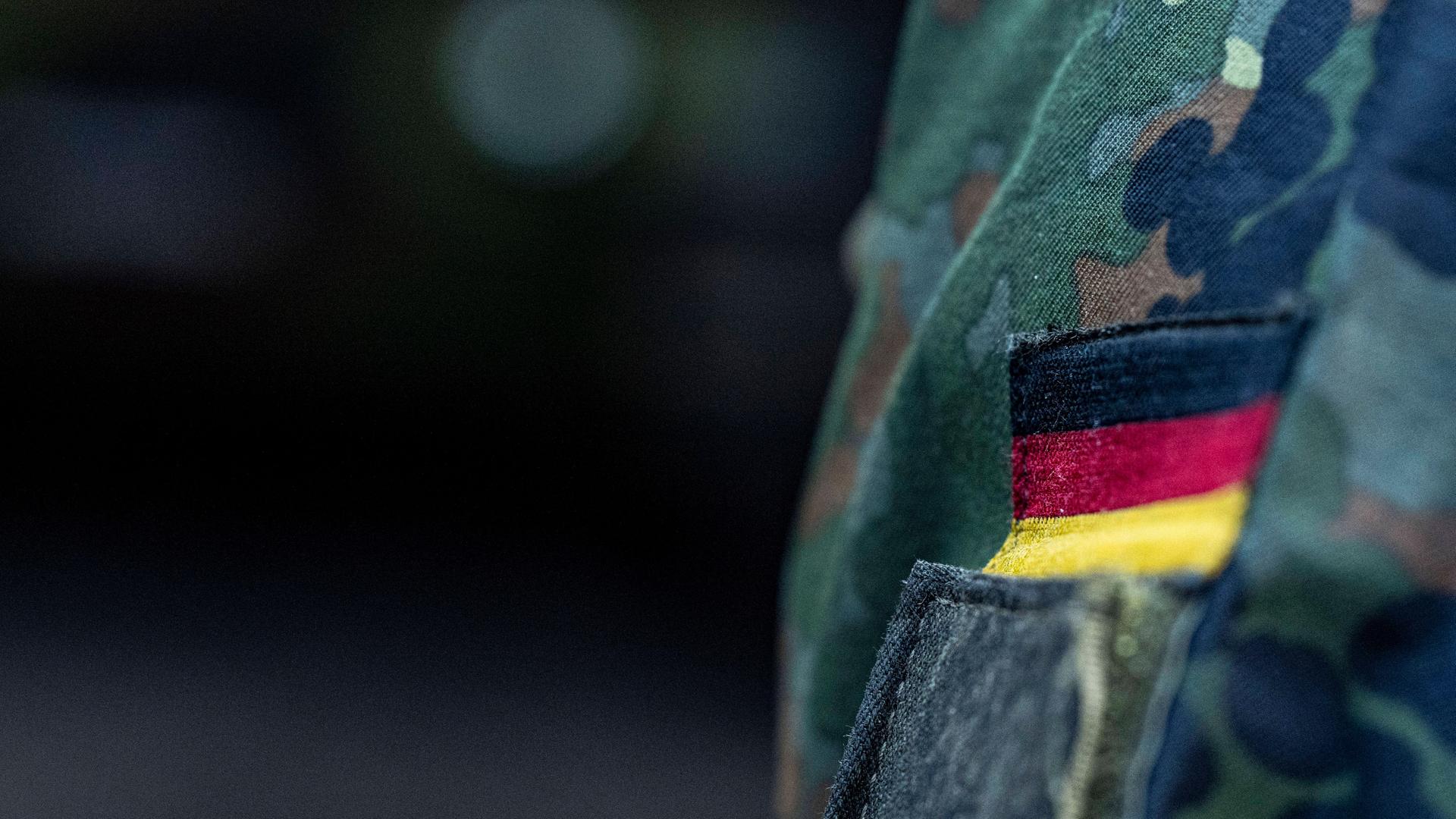 Abzeichen mit Deutschlandfahne auf einer Bundeswehr-Uniform aus der Nahaufnahme 