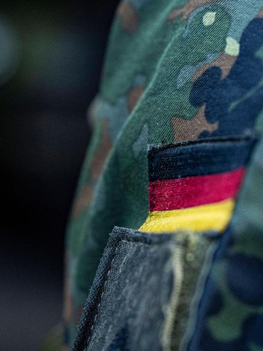 Abzeichen mit Deutschlandfahne auf einer Bundeswehr-Uniform aus der Nahaufnahme 