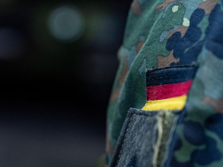 Abzeichen mit Deutschlandfahne auf einer Bundeswehr-Uniform aus der Nahaufnahme 