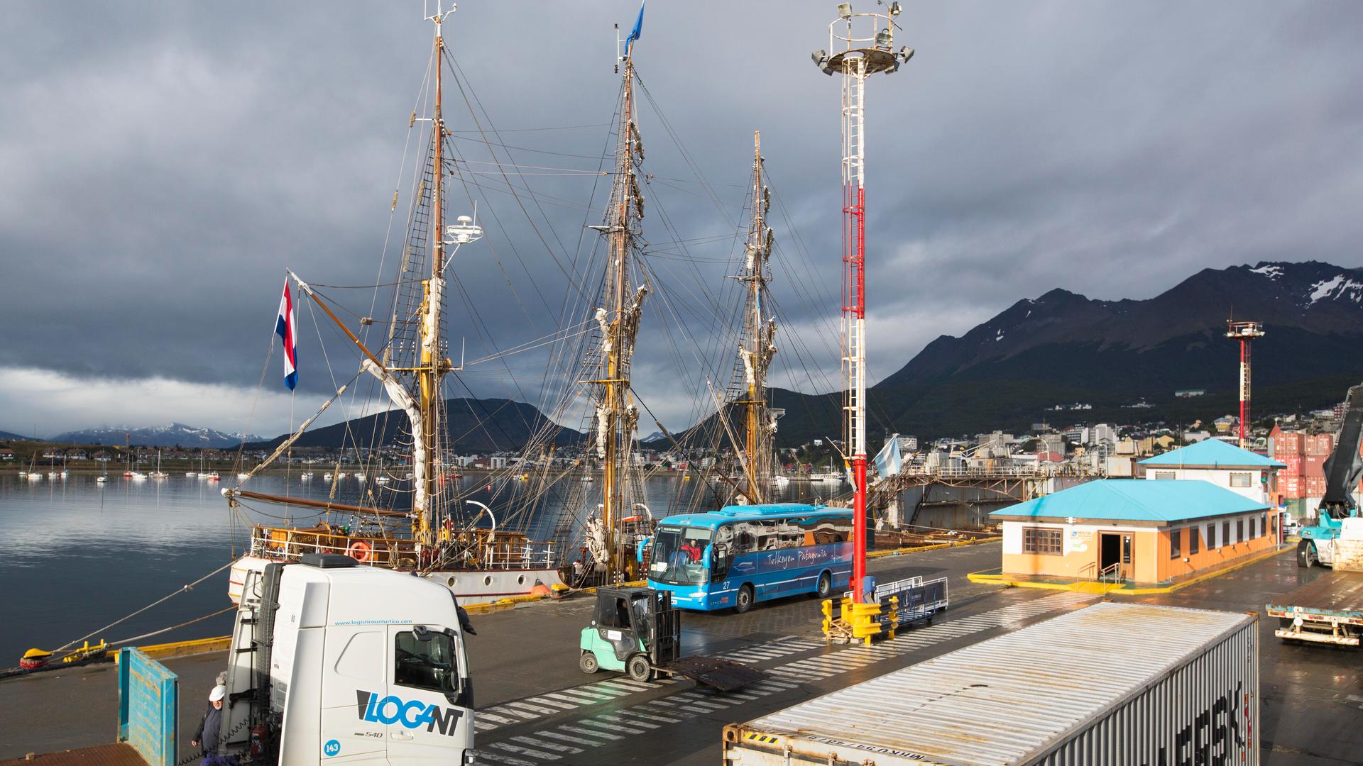 Ein Containerschiff und ein altes Holzsegelschiff am Hafen von Ushuaia, Argentinien