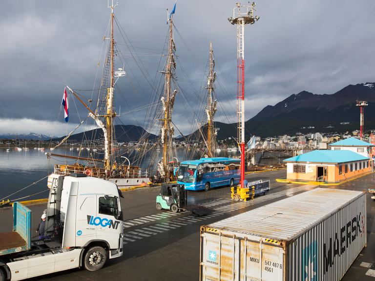 Ein Containerschiff und ein altes Holzsegelschiff am Hafen von Ushuaia, Argentinien