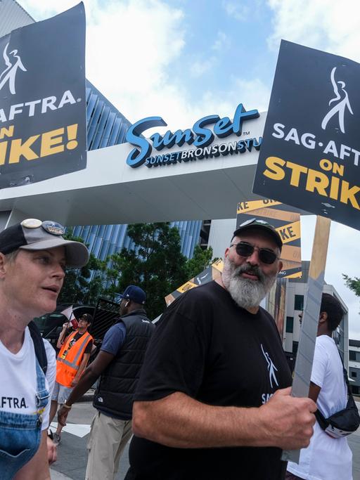 Mitglieder der SAG-AFTRA-Gewerkschaft protestieren mit Schildern vor den Sunset Bronson Studios in Los Angeles.