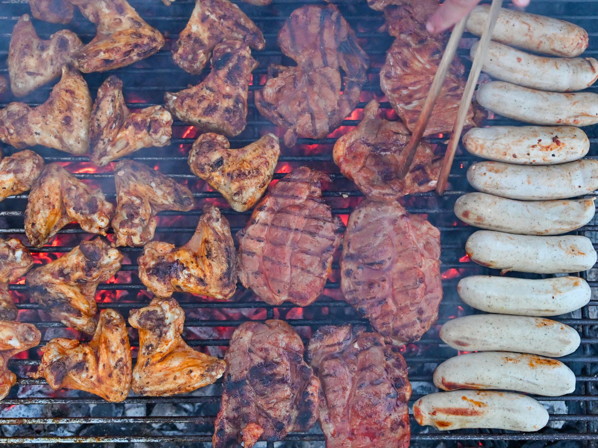 Grillfleisch liegt auf einem Holzkohlegrill.