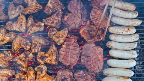 Grillfleisch liegt auf einem Holzkohlegrill.