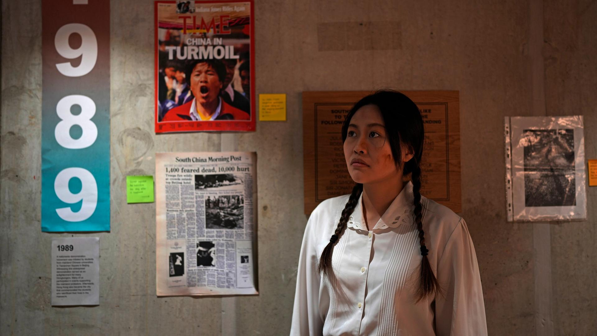 Carmen Lau vor Plakaten, die an die gewaltsame Niederschlagung der Demokratieproteste auf dem Tiananmen-Platz in Peking erinnern.