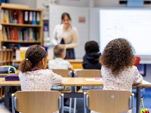 Schüler einer 2. Klasse sitzen in einer Schulstunde auf ihren Plätzen