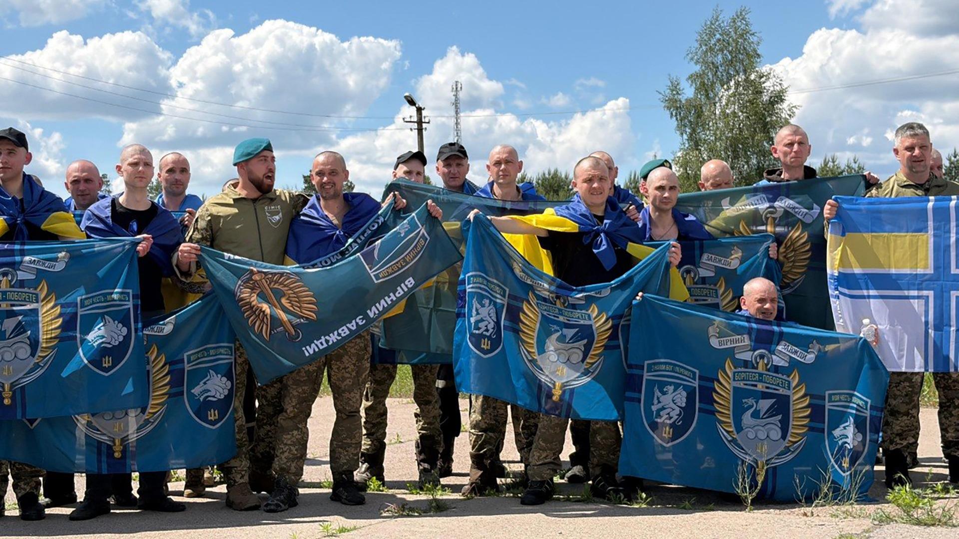 Eine Gruppe ukrainischer Soldaten posieren mit Flaggen nach ihrer Freilassung aus der Kriegsgefangenschaft.