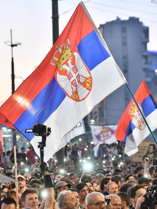 Tausende Menschen demonstrieren in Belgrad gegen die Regierung, sie schwenken serbische Flaggen und leuchten mit ihren Handy-Taschenlampen