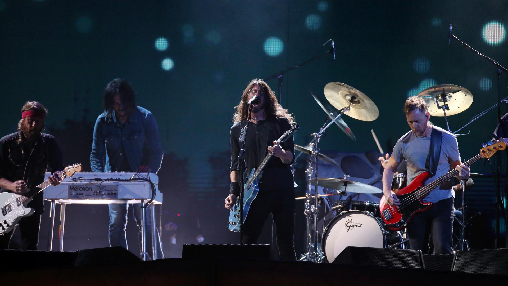 Mitglieder der US-Rockband Foo Fighters stehen bei einem Konzert auf der Bühne.
