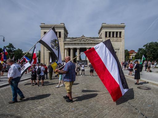 Reichsbürger am Königsplatz in München. Einer trägt die Preußenflagge, ein anderer die Flagge des deutschen Kaiserreichs