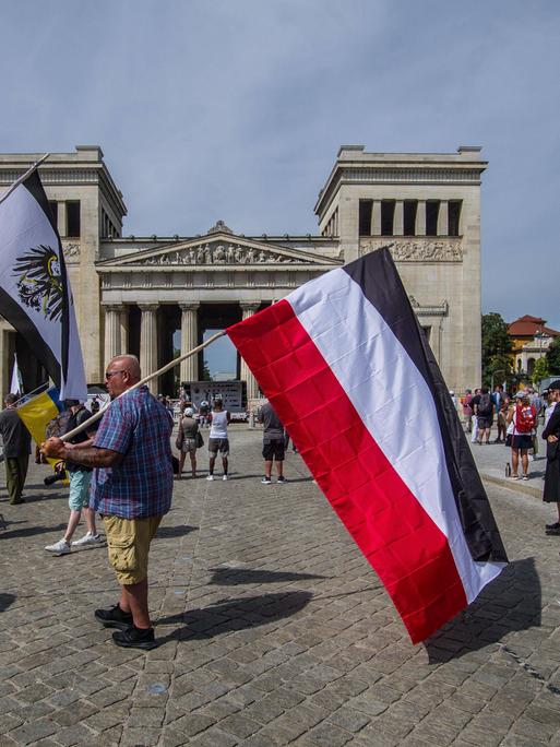 Reichsbürger am Königsplatz in München. Einer trägt die Preußenflagge, ein anderer die Flagge des deutschen Kaiserreichs