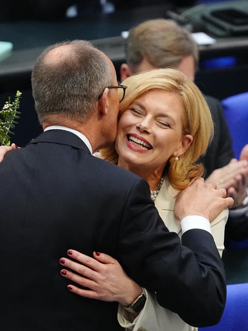 Julia Klöckner (CDU) nimmt nach ihrer Wahl zur Bundestagspräsidentin Glückwünsche und ein Küsschen von Friedrich Merz entgegen (25.3.2025)