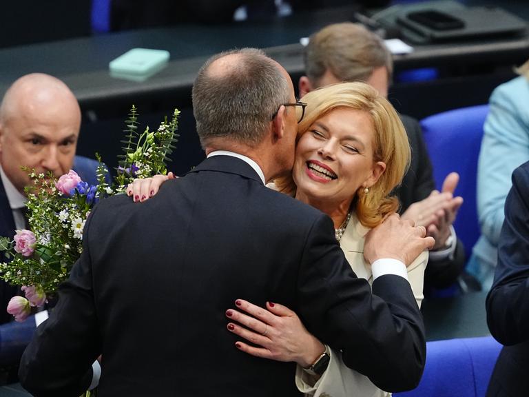 Julia Klöckner (CDU) nimmt nach ihrer Wahl zur Bundestagspräsidentin Glückwünsche und ein Küsschen von Friedrich Merz entgegen (25.3.2025)