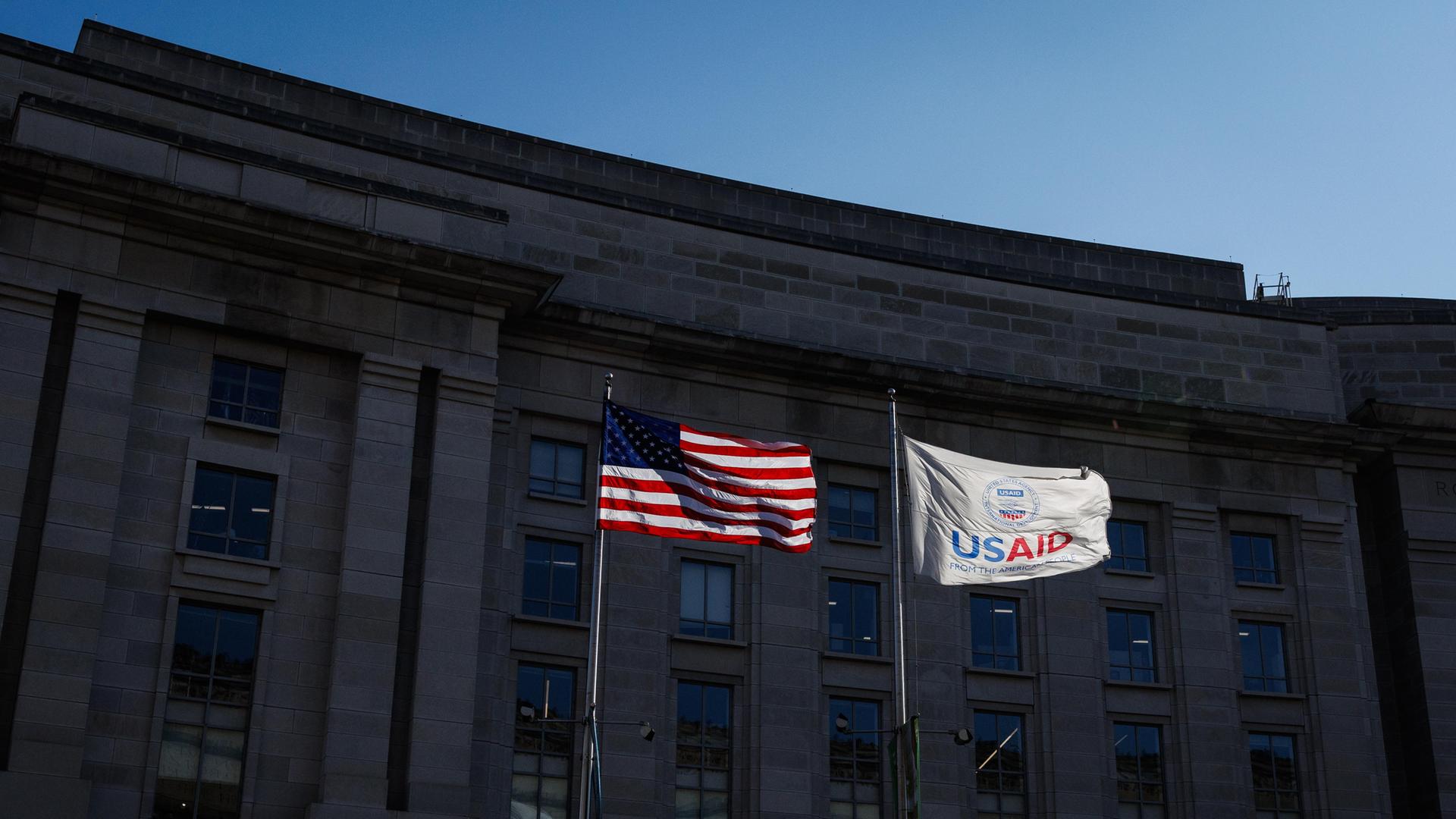 Vor dem Gebäude von USAID, der US-amerikanischen Entwicklungshilfebehörde, wehen die US-Flagge und die USAID-Flagge.