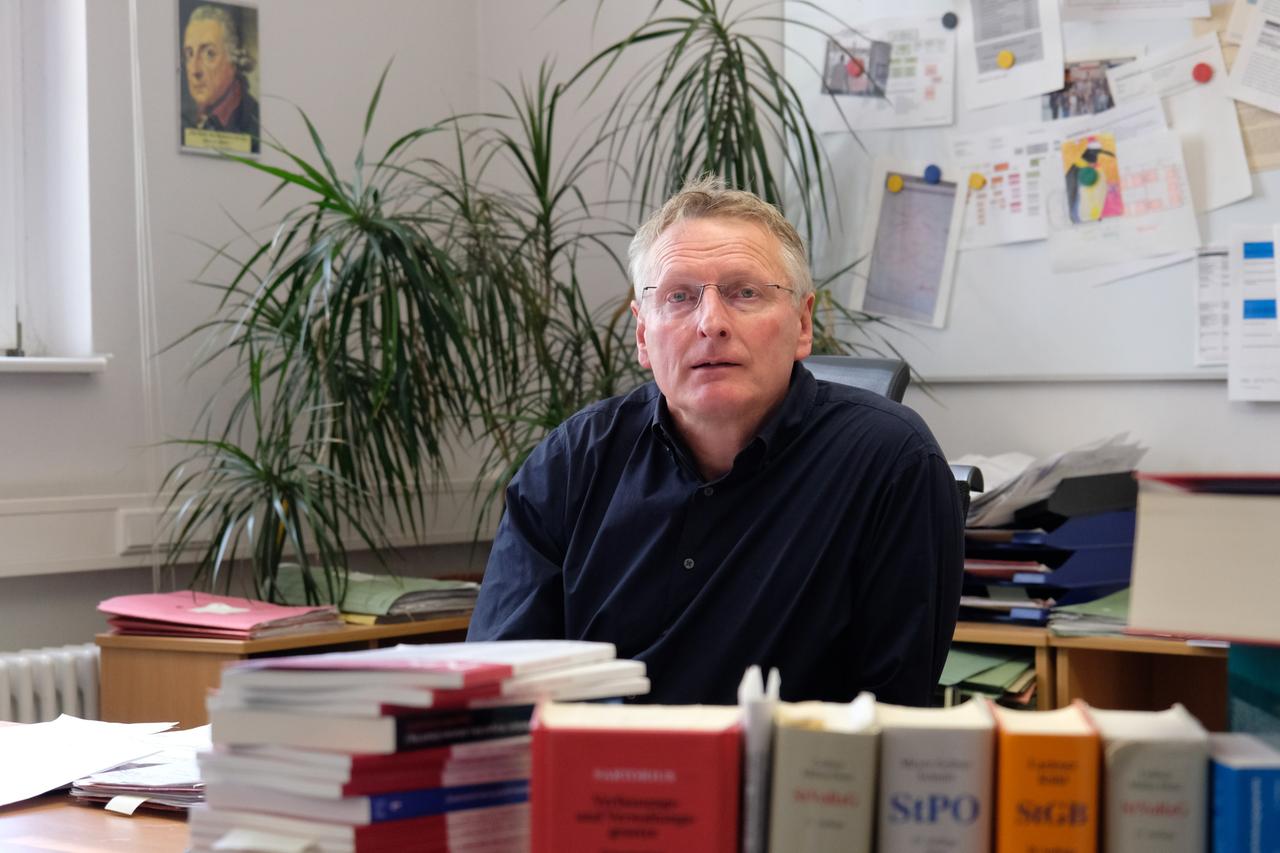 Porträt von Uwe Meyer-Odewald, der seit sechs Jahren die JVA Plötzensee leitet. Er sitzt in einem Büro hinter Aktenordnern.