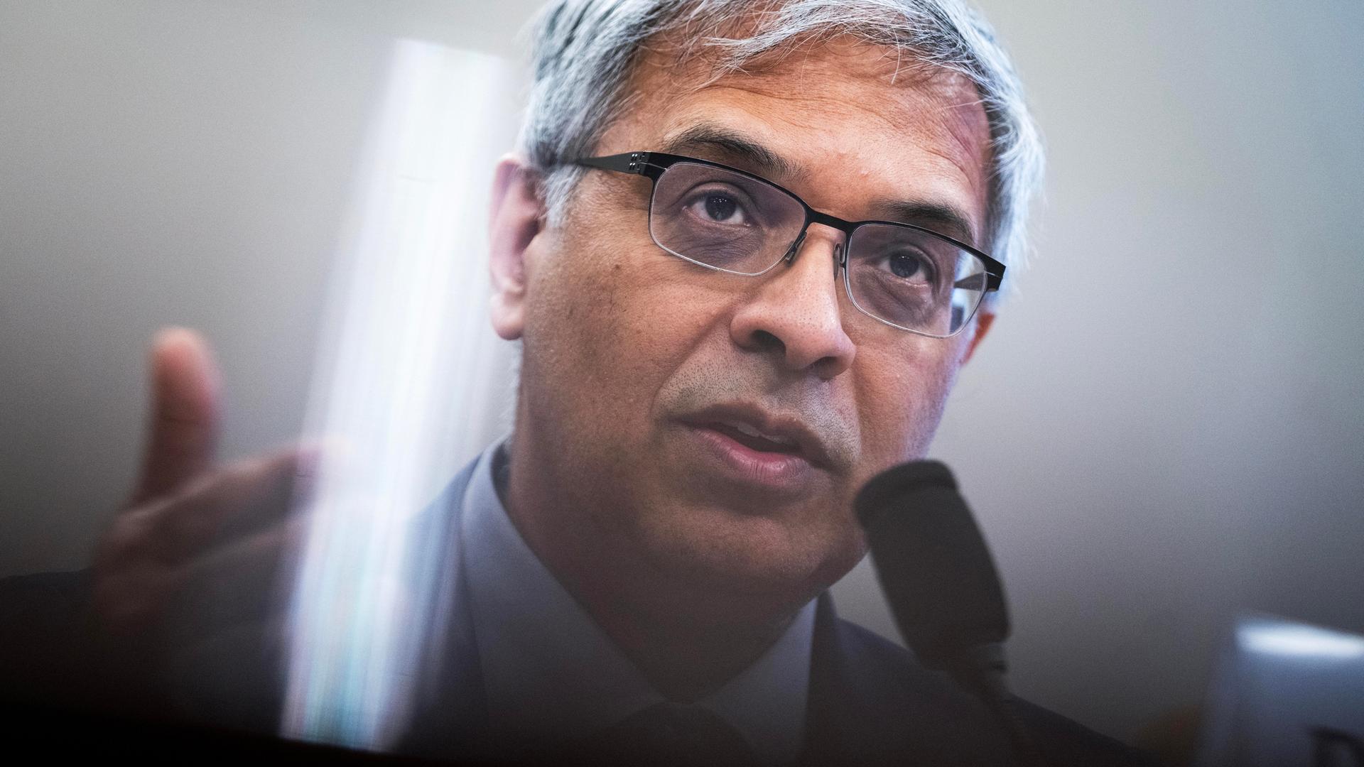 Ein Mann mit Brille spricht, vor ihm ist ein Mikrofon. Es ist Jay Bhattacharya.