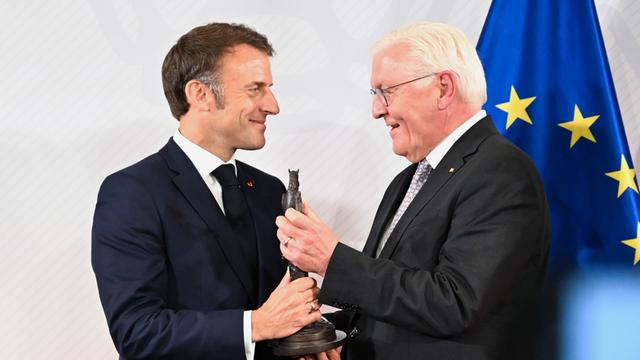 BundespräDas Foto zeigt Bundes-Präsident Frank-Walter Steinmeier (rechts), Frankreichs Präsident Emmanuel Macron in Münster den Westfälischen Friedens-Preis überreicht. Im Hintergrund ist eine Europa-Fahne.