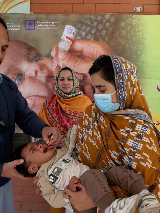 Ein Gesundheitsarbeiter verabreicht einem Kind in einem Gesundheitszentrum einen Polio-Impfstoff in Peschawar, Pakistan.