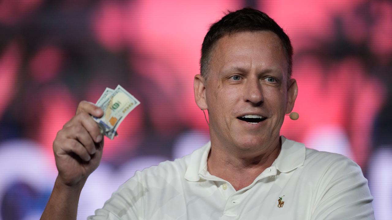Peter Thiel, Mitbegründer von PayPal and Palantir, zeigt Mitgliedern ein paar 100-Dollar-Noten während einer Bitcoin Konferenz am 7. April 2022 in Miami Beach, Florida. Er gilt als Sponsor der Republikaner und von JD Vance.