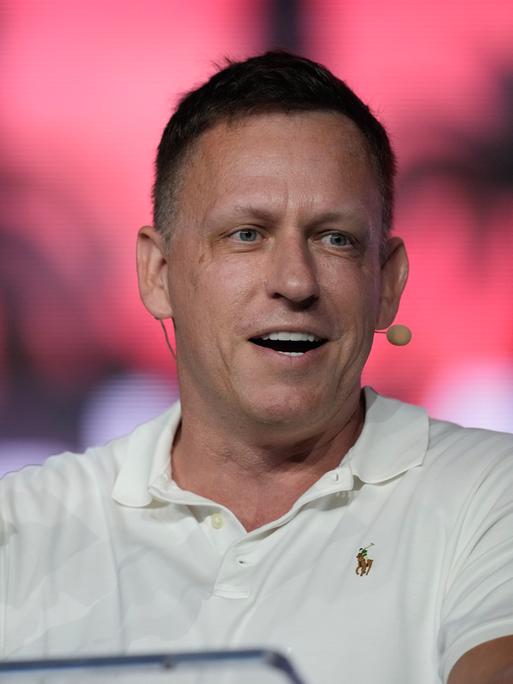 Peter Thiel, Mitbegründer von PayPal and Palantir, zeigt Mitgliedern ein paar 100-Dollar-Noten während einer Bitcoin Konferenz am 7. April 2022 in Miami Beach, Florida. Er gilt als Sponsor der Republikaner und von JD Vance.