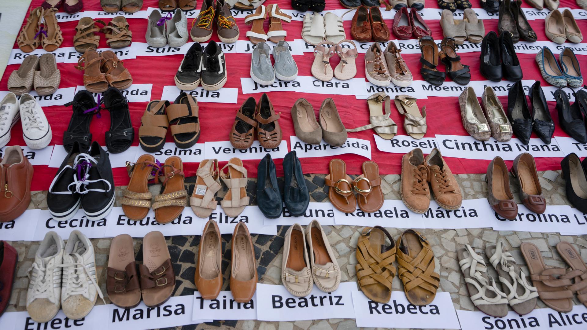 Viele aufgereihte Frauenschuhe mit den Namen von Frauen, die im Jahr 2022 in Brasilien Opfer von Femiziden wurden. Internationaler Tag für die Beseitigung von Gewalt gegen Frauen, am Strand der Copacabana in Rio de Janeiro, Brasilien, November 2023.