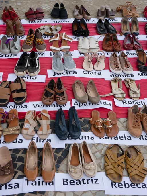 Viele aufgereihte Frauenschuhe mit den Namen von Frauen, die im Jahr 2022 in Brasilien Opfer von Femiziden wurden. Internationaler Tag für die Beseitigung von Gewalt gegen Frauen, am Strand der Copacabana in Rio de Janeiro, Brasilien, November 2023.