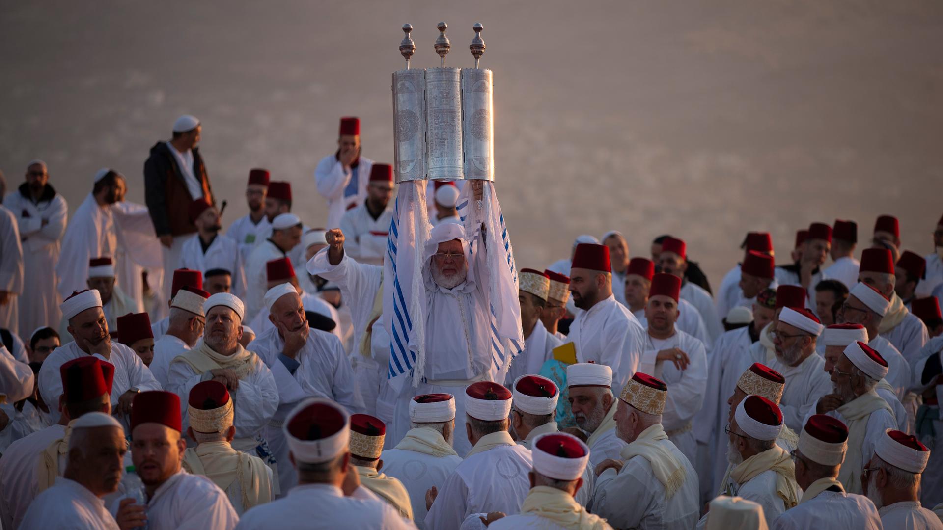 Samaritaner in traditionellen Gewändern bei einem Ritual mit Thora-Rolle. Samaritaner in traditionellen Gewändern bei einem Ritual mit Thora-Rolle.