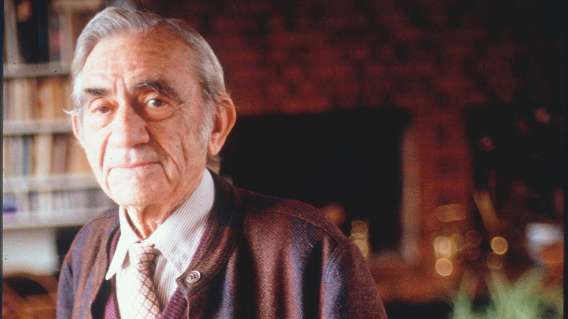 Pierre Schaeffer in Porträtaufnahme in seiner Wohnung, in der er vor Bücherregalen steht. Pierre Schaeffer in Porträtaufnahme in seiner Wohnung, in der er vor Bücherregalen steht.