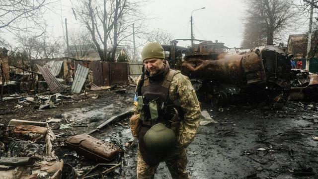 Das Foto zeigt einen ukrainischen Soldaten in der Stadt Butscha. Die Straße ist zerstört. 