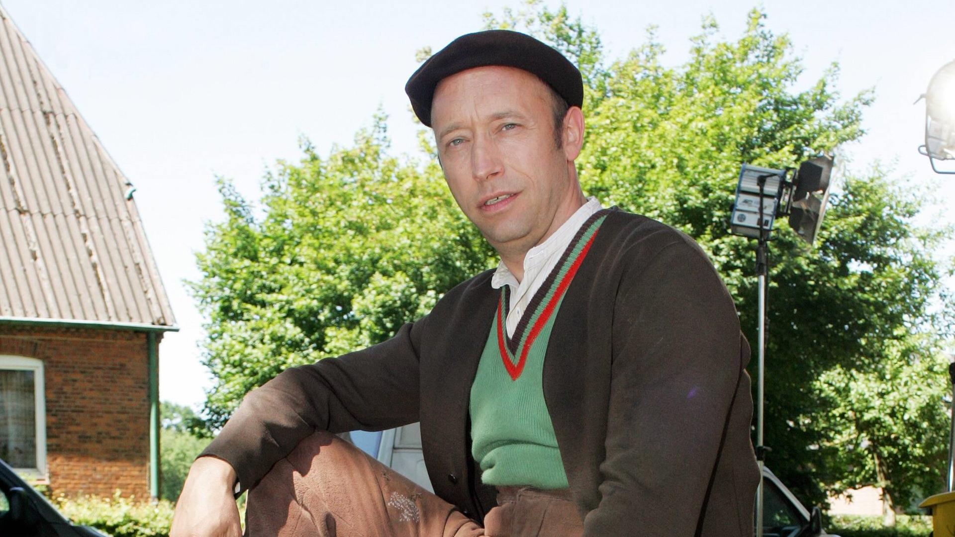 Der Schauspieler Sven Walser sitzt auf einer Mauer und schaut in die Kamera. Der Schauspieler Sven Walser sitzt auf einer Mauer und schaut in die Kamera.