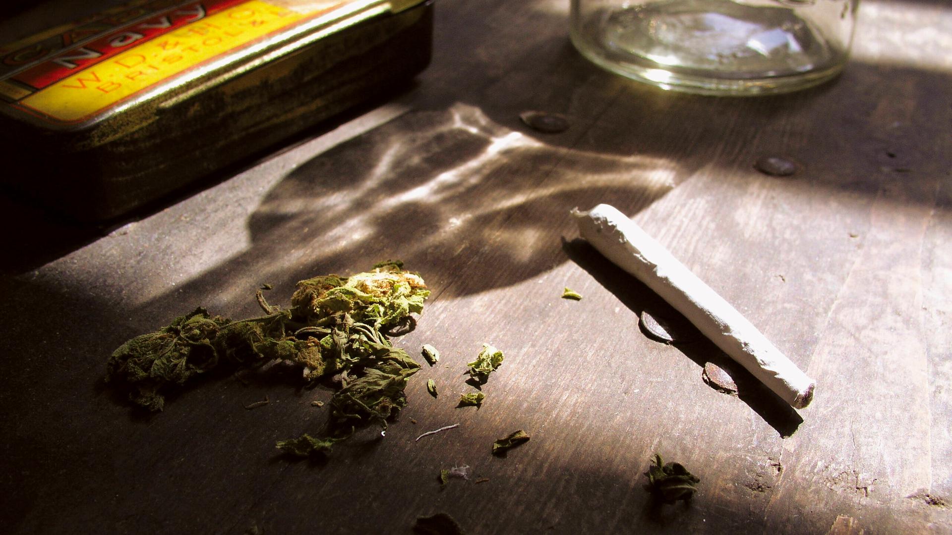 Ein Joint und Cannabis liegen auf einem Tisch. 