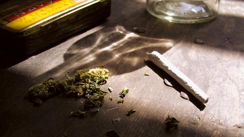 Ein Joint und Cannabis liegen auf einem Tisch. 