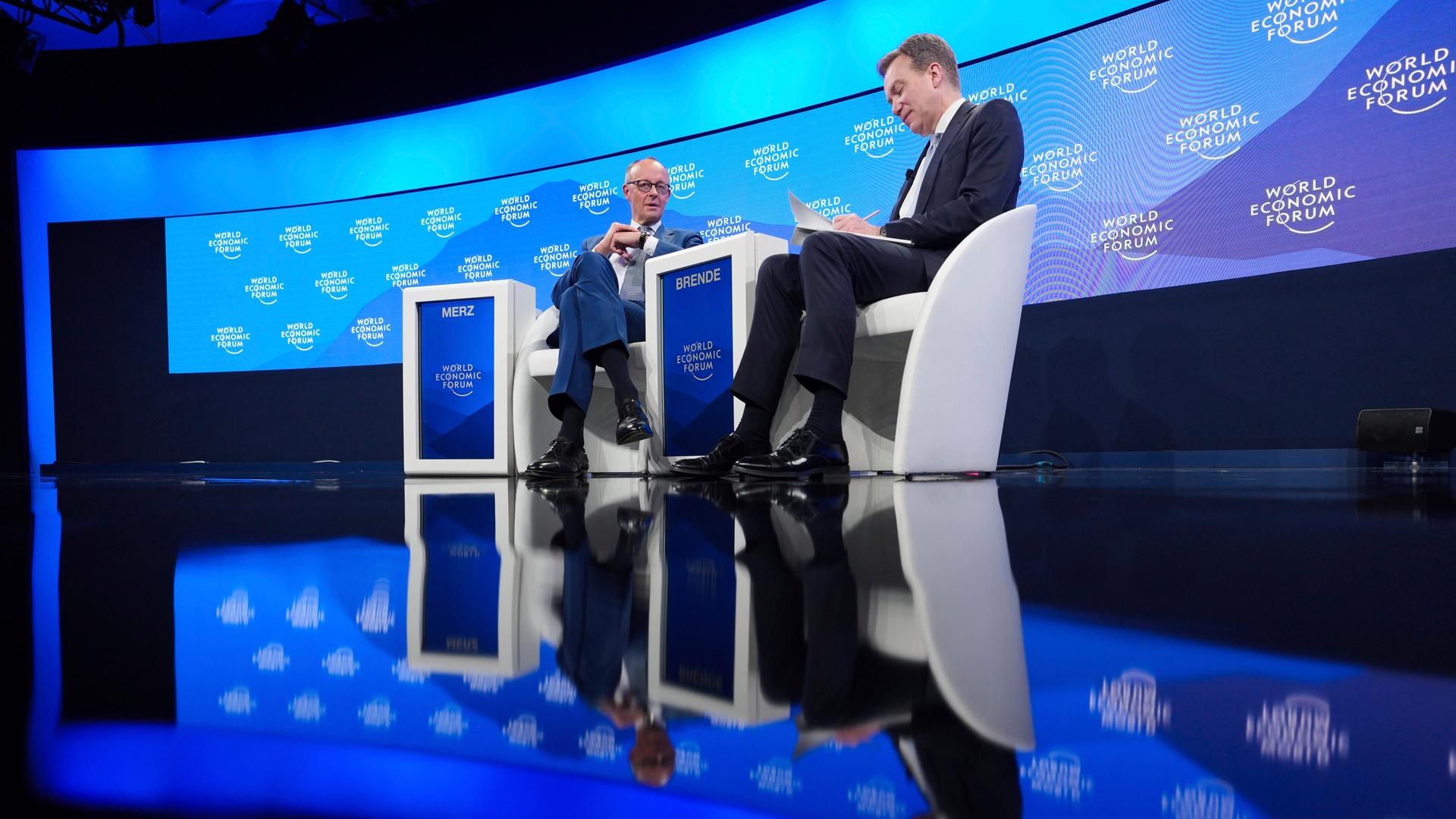 CDU-Kanzlerkandidat Friedrich Merz, links im Bild, im Gespräch mit dem Präsidenten des Weltwirtschaftsforums Borge Brende auf der Bühne in Davos