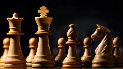 Das Bild zeigt Schachfiguren, die um den weißen König gruppiert sind. 